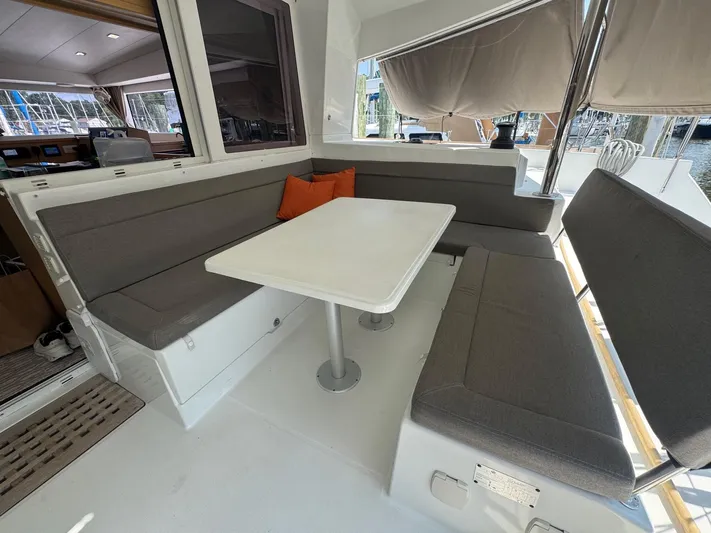 Serenity Yacht Photos Pics Spacious seating area on a 2016 Lagoon 400 S2 catamaran with cushioned benches and table.