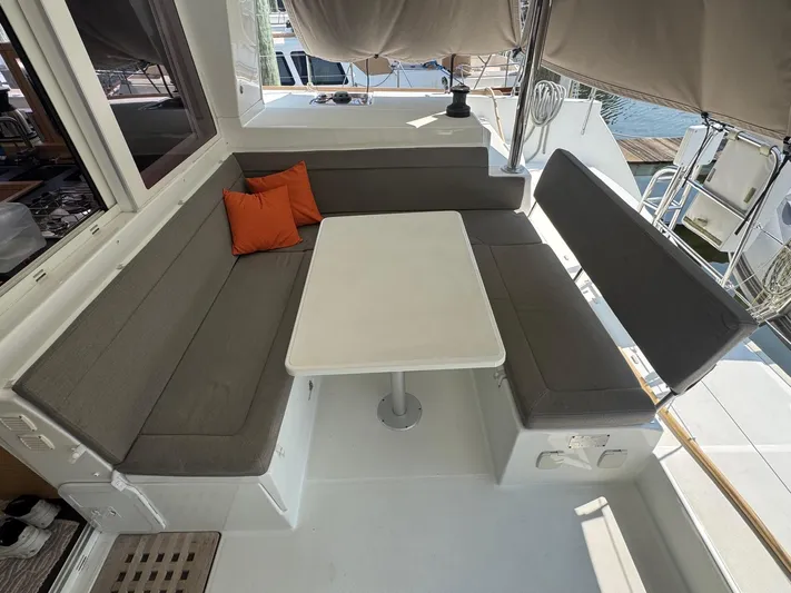Serenity Yacht Photos Pics Cozy seating area on 2016 Lagoon 400 S2 catamaran with gray cushions and orange pillows.