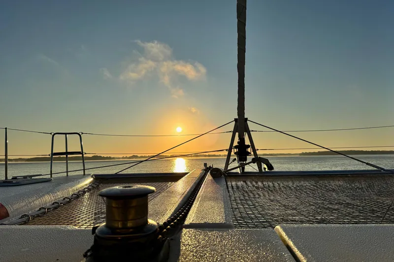Serenity Yacht Photos Pics Sunset view from 2016 Lagoon 400 S2 catamaran deck, calm waters, serene atmosphere.