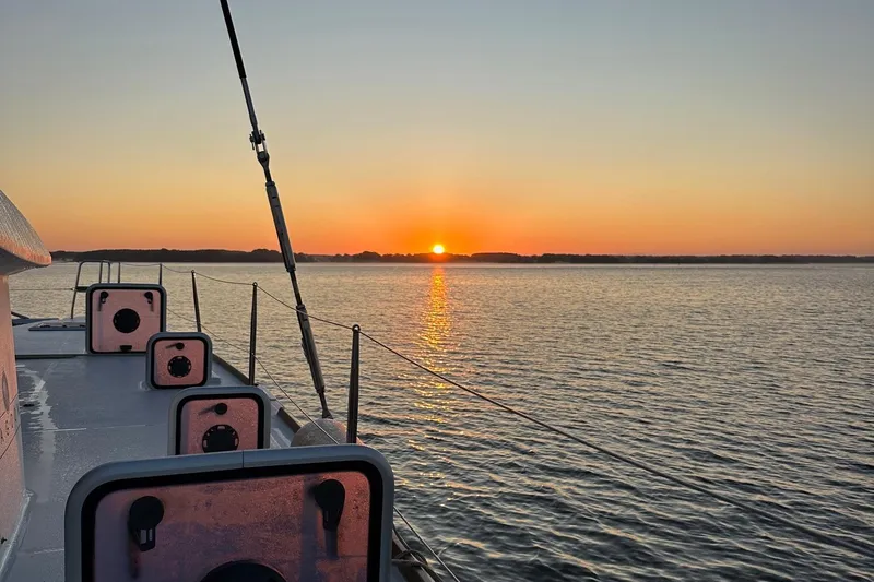 Serenity Yacht Photos Pics Sunset view from a 2016 Lagoon 400 S2 catamaran on calm waters.