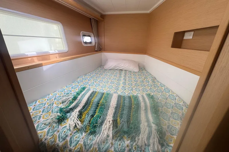 Serenity Yacht Photos Pics Cozy cabin interior of 2016 Lagoon 400 S2 with patterned bedding and window.