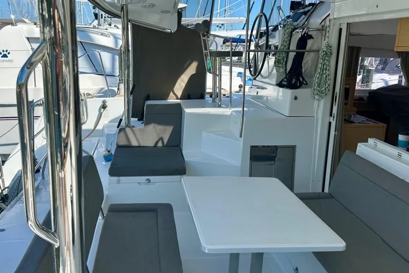 Serenity Yacht Photos Pics 2016 Lagoon 400 S2 yacht interior with seating and table, docked at marina.