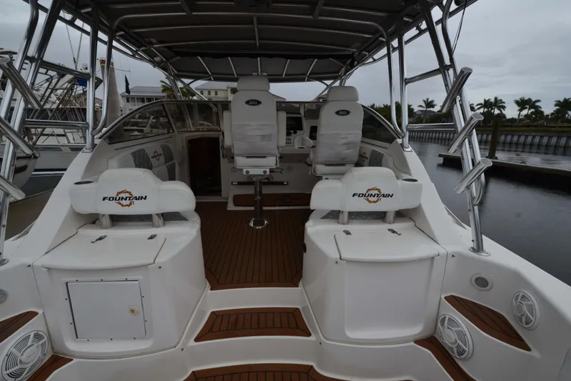 Flying Norseman II Yacht Photos Pics 2007 Fountain 38 Sportfish Cruiser OB, spacious deck with seating, docked by the water.