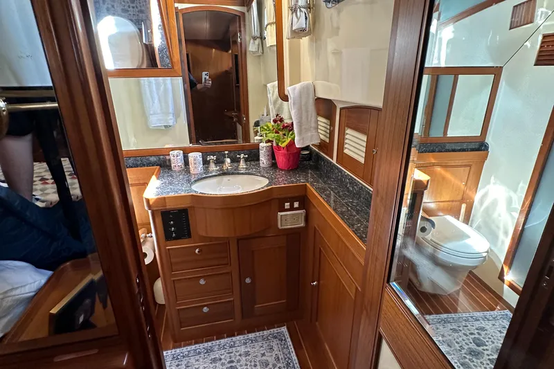 Miss Stephanie Yacht Photos Pics Luxurious bathroom in a 2008 Marlow 70 Explorer yacht with wooden cabinetry and granite countertops.