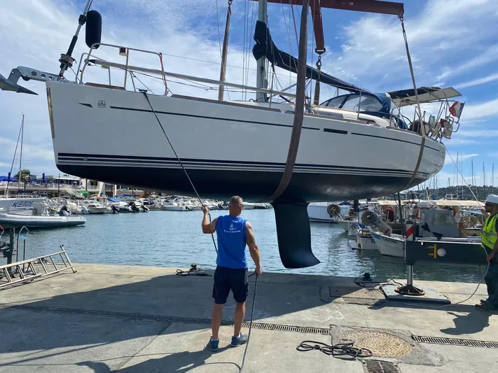  Yacht Photos Pics Dufour 34 Performance 2006 sailboat being lifted at a marina with clear skies.
