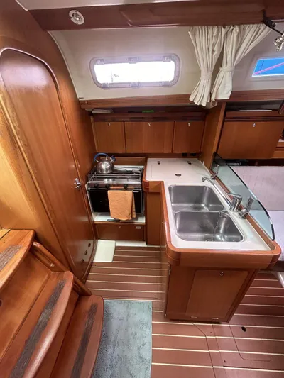  Yacht Photos Pics Interior of 2006 Dufour 34 Performance yacht, featuring a compact kitchen with wooden cabinetry.