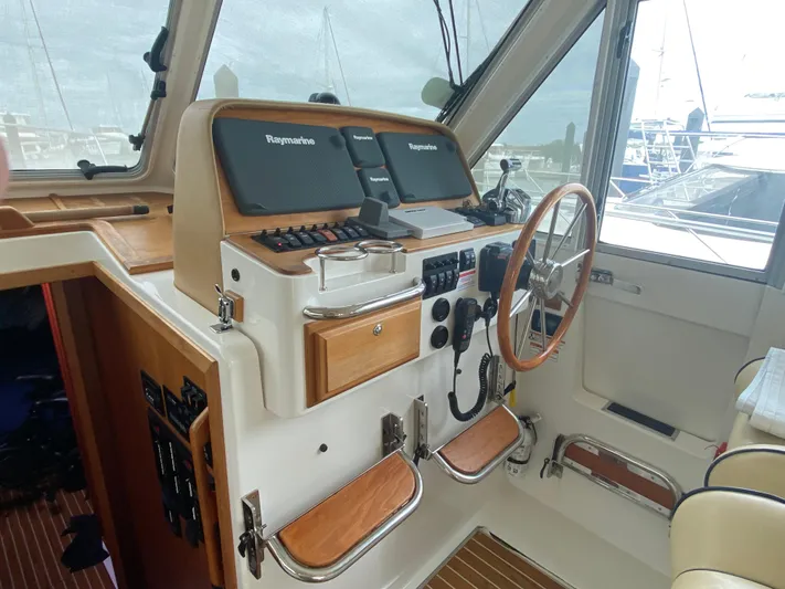  Yacht Photos Pics Interior helm of 2014 Back Cove 41 boat with navigation equipment and wooden accents.