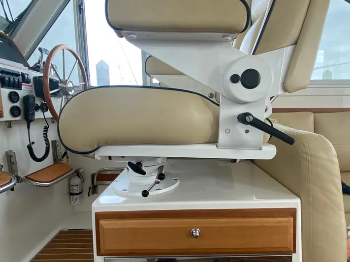  Yacht Photos Pics Captain's chair and helm of 2014 Back Cove 41 boat, featuring beige upholstery and wooden accents.