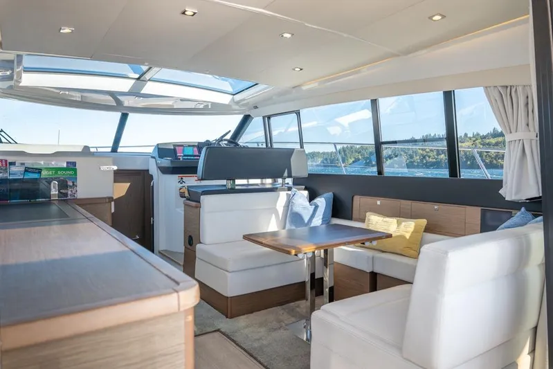 Bee's Knees Yacht Photos Pics Luxurious interior of 2017 Jeanneau NC 14 yacht with panoramic windows and modern seating.