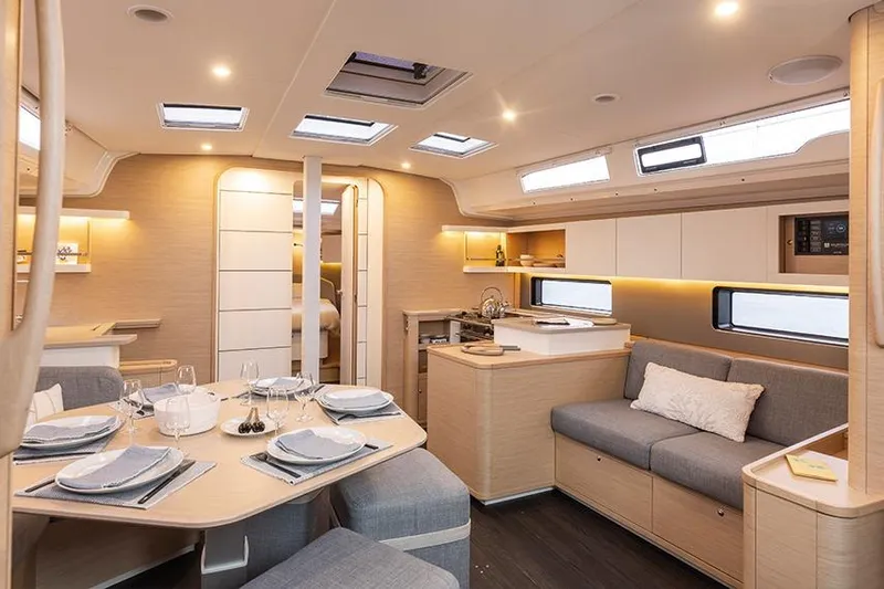  Yacht Photos Pics Luxurious interior of 2025 Dufour 44 yacht with modern dining and seating area.