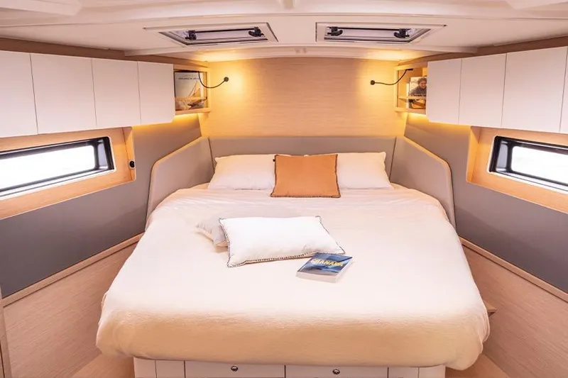  Yacht Photos Pics Luxurious cabin interior of 2025 Dufour 44 yacht with cozy bed and ambient lighting.