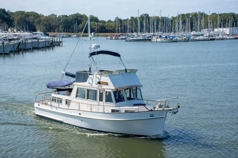  Yacht Photos Pics 1990 Grand Banks 36 Classic yacht cruising in a marina with sailboats in the background.