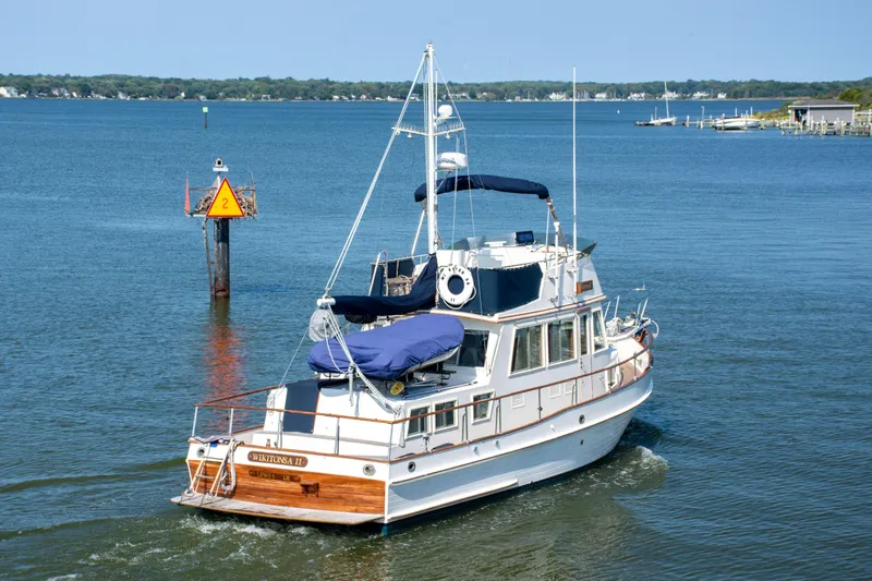  Yacht Photos Pics 1990 Grand Banks 36 Classic yacht cruising on a calm lake with clear skies.