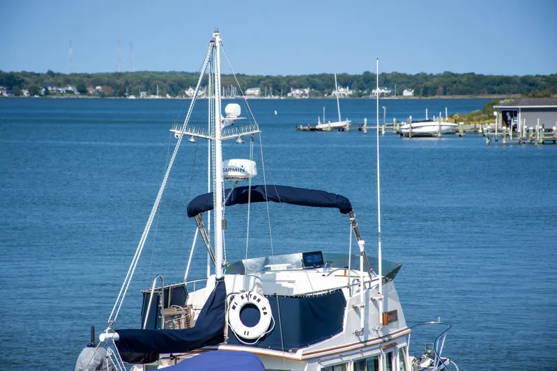  Yacht Photos Pics 1990 Grand Banks 36 Classic yacht on serene blue waters with distant shoreline.