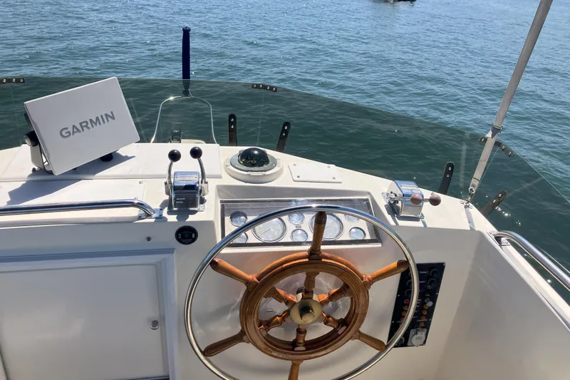  Yacht Photos Pics Helm of 1990 Grand Banks 36 Classic with Garmin navigation, wooden wheel, and ocean view.
