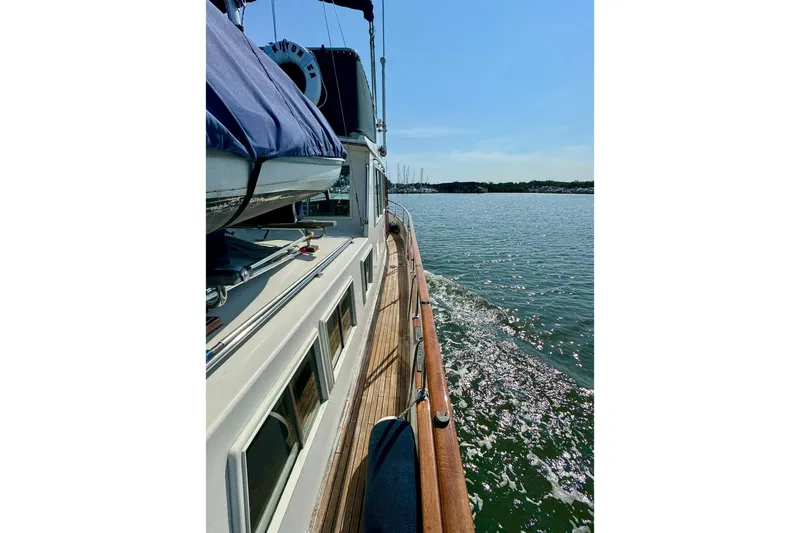  Yacht Photos Pics 1990 Grand Banks 36 Classic cruising on calm waters under clear blue sky.