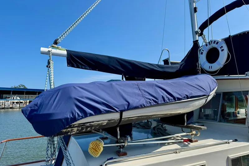  Yacht Photos Pics 1990 Grand Banks 36 Classic yacht with covered dinghy on deck, docked under clear blue sky.