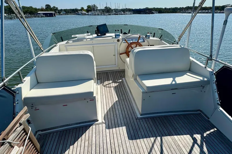  Yacht Photos Pics 1990 Grand Banks 36 Classic yacht deck with seating and steering wheel, overlooking calm waters.