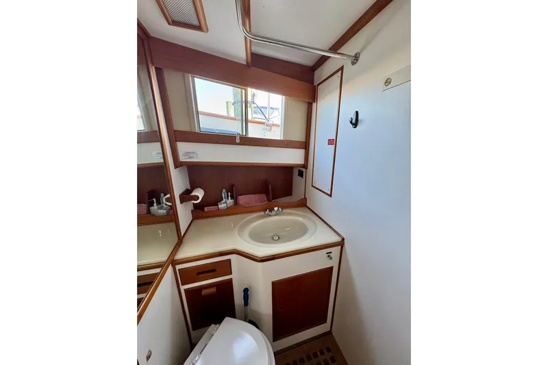  Yacht Photos Pics Bathroom interior of 1990 Grand Banks 36 Classic yacht, featuring sink and wooden cabinetry.