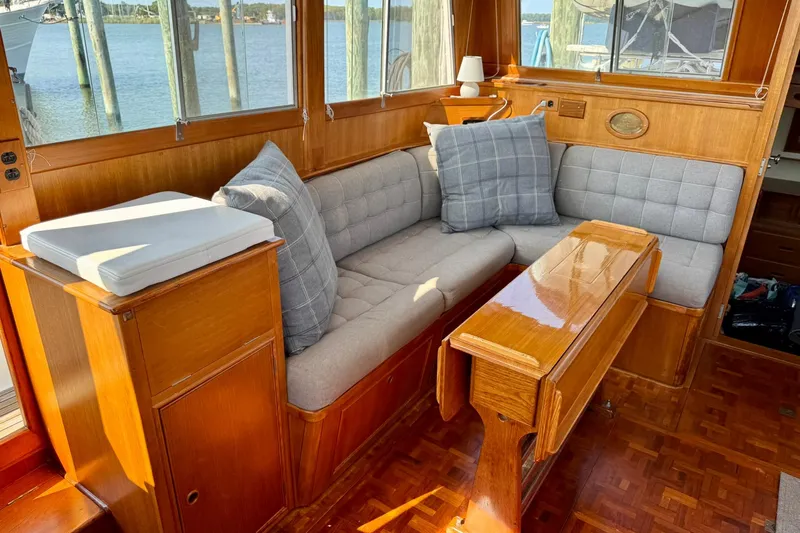  Yacht Photos Pics Cozy interior of 1990 Grand Banks 36 Classic yacht with wooden furnishings and cushioned seating.