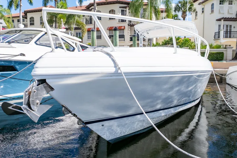  Yacht Photos Pics 2003 Intrepid 370 Cuddy boat docked in a marina, surrounded by palm trees.