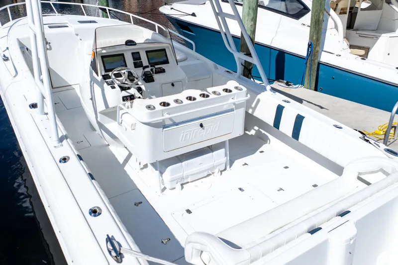  Yacht Photos Pics 2003 Intrepid 370 Cuddy boat interior with helm, seating, and fishing rod holders.