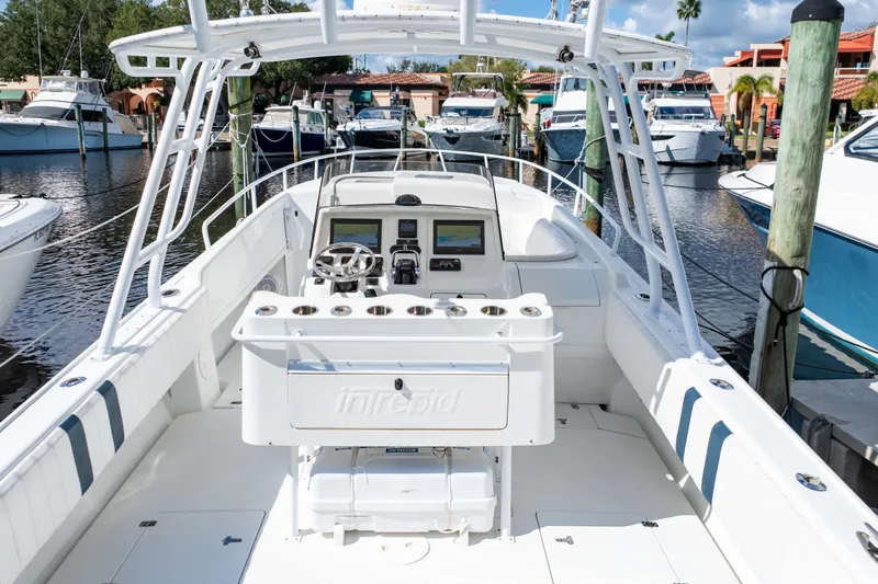  Yacht Photos Pics 2003 Intrepid 370 Cuddy boat interior at marina, featuring helm and seating area.
