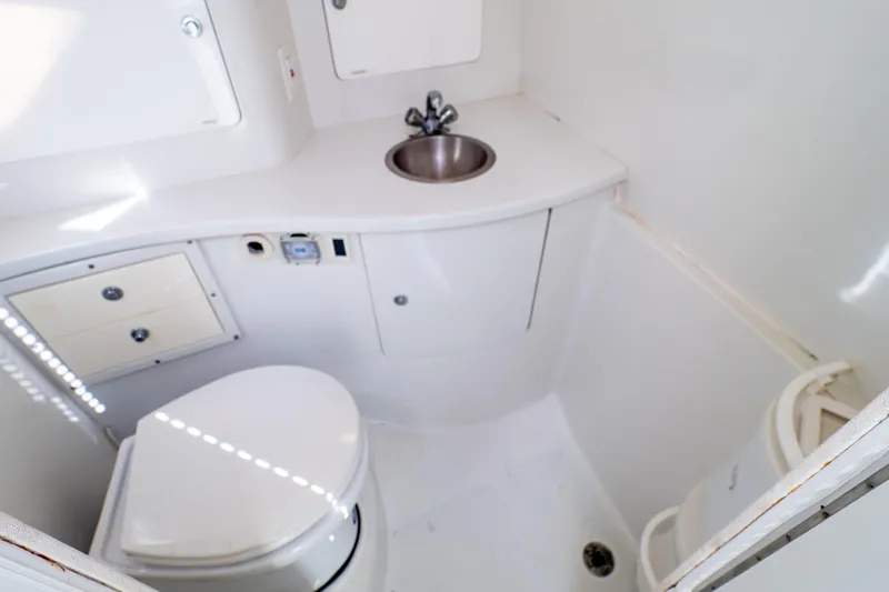  Yacht Photos Pics 2003 Intrepid 370 Cuddy boat bathroom with toilet, sink, and storage cabinets.
