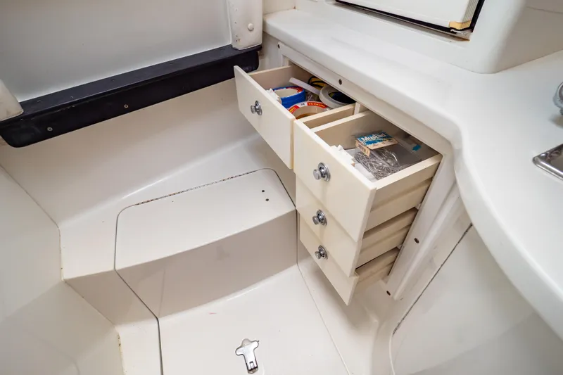  Yacht Photos Pics 2003 Intrepid 370 Cuddy interior with open storage drawers and various items.