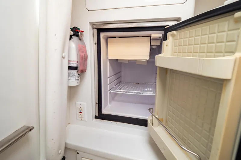  Yacht Photos Pics Open refrigerator inside 2003 Intrepid 370 Cuddy boat, with fire extinguisher nearby.
