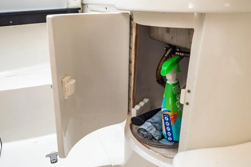  Yacht Photos Pics Open storage compartment on 2003 Intrepid 370 Cuddy boat with cleaning supplies inside.