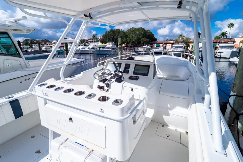  Yacht Photos Pics 2003 Intrepid 370 Cuddy boat interior at marina, featuring helm and seating area.