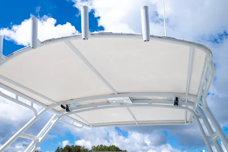  Yacht Photos Pics 2003 Intrepid 370 Cuddy boat canopy against a bright blue sky with clouds.