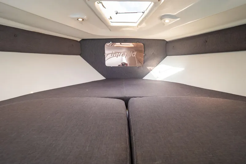  Yacht Photos Pics Interior cabin of 2003 Intrepid 370 Cuddy boat, featuring cushioned seating and overhead lighting.