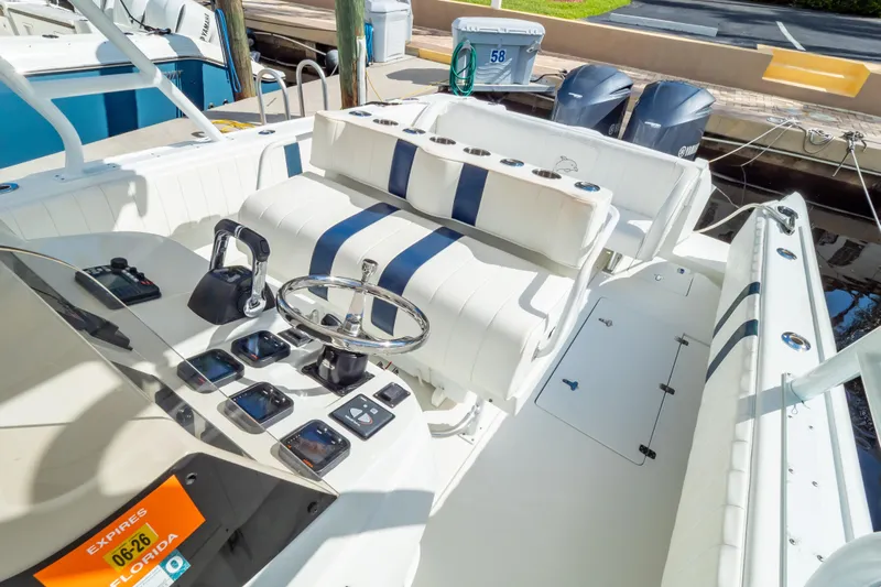  Yacht Photos Pics 2003 Intrepid 370 Cuddy boat interior with steering wheel and seating, docked by the water.
