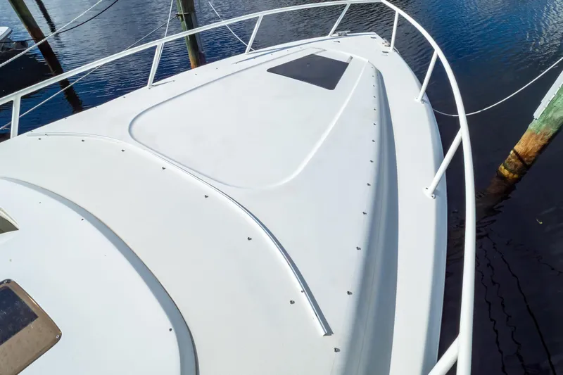  Yacht Photos Pics 2003 Intrepid 370 Cuddy boat deck, white surface, docked on calm water.