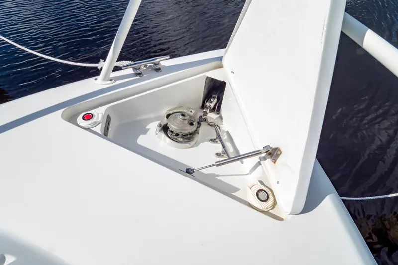  Yacht Photos Pics Anchor compartment of 2003 Intrepid 370 Cuddy boat, open hatch, calm water background.