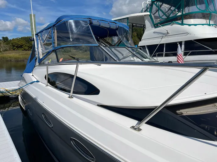 Souper Tuscan Yacht Photos Pics 2011 Regal 35 Express Cruiser docked, featuring sleek design and blue canopy.