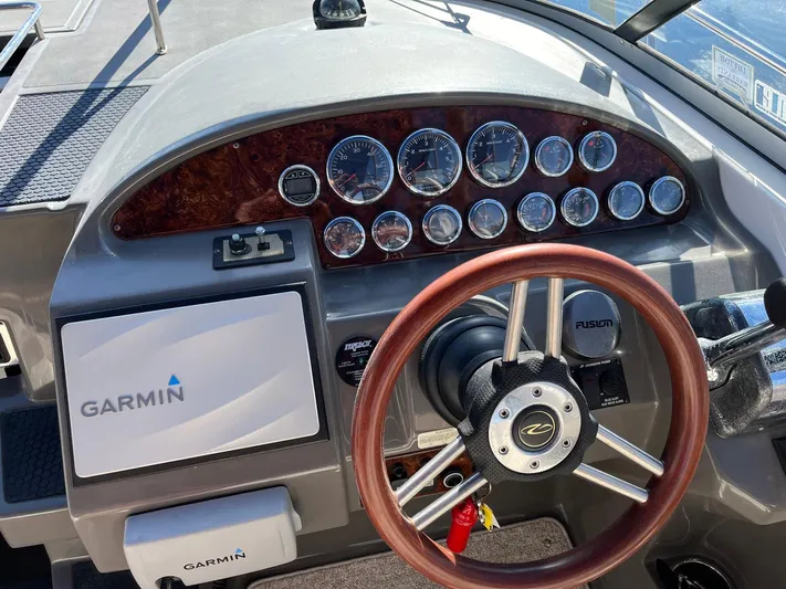 Souper Tuscan Yacht Photos Pics 2011 Regal 35 Express Cruiser dashboard with Garmin navigation and wood-trimmed steering wheel.