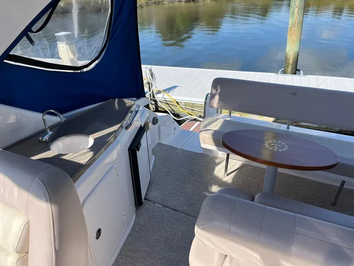 Souper Tuscan Yacht Photos Pics 2011 Regal 35 Express Cruiser interior with seating, table, and sink by the water.