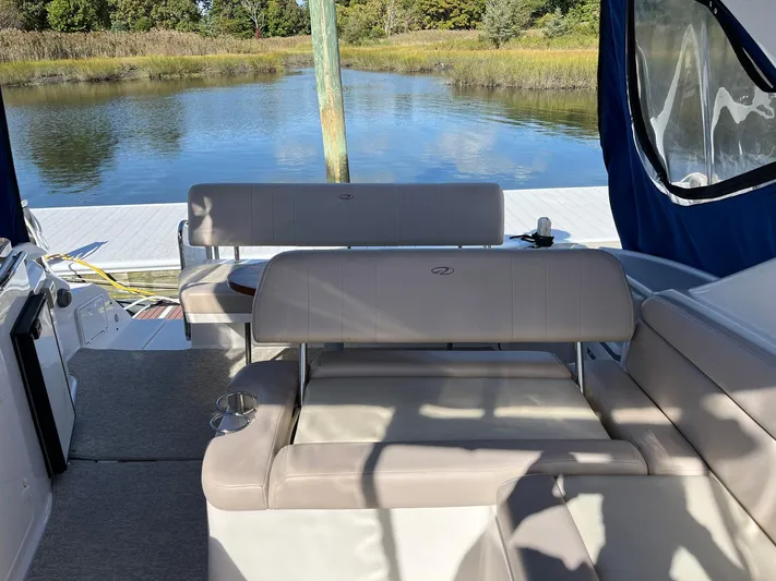 Souper Tuscan Yacht Photos Pics 2011 Regal 35 Express Cruiser interior with seating, docked by a serene lake.