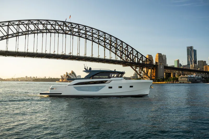 Bgx63 Yacht Photos Pics 2024 Bluegame BGX63 yacht cruising near iconic bridge and city skyline.