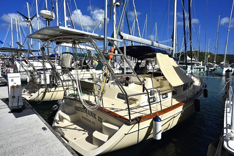 Watermark Lll Yacht Photos Pics 2005 Island Packet 445 sailboat docked in a marina under a clear blue sky.