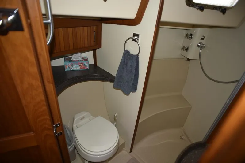 Watermark Lll Yacht Photos Pics Bathroom interior of 2005 Island Packet 445 yacht, featuring toilet, shower, and wooden cabinetry.