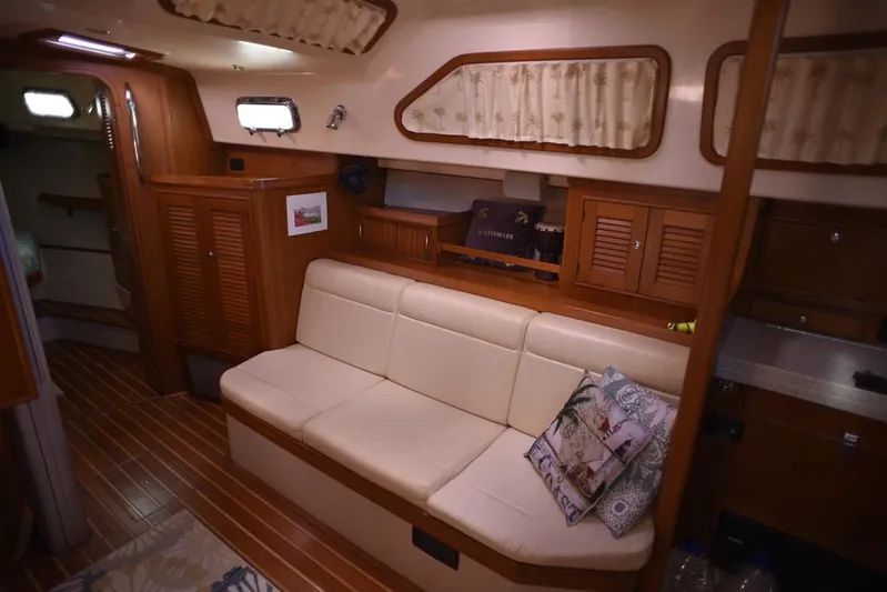 Watermark Lll Yacht Photos Pics Interior of 2005 Island Packet 445 yacht with beige sofa and wooden cabinetry.