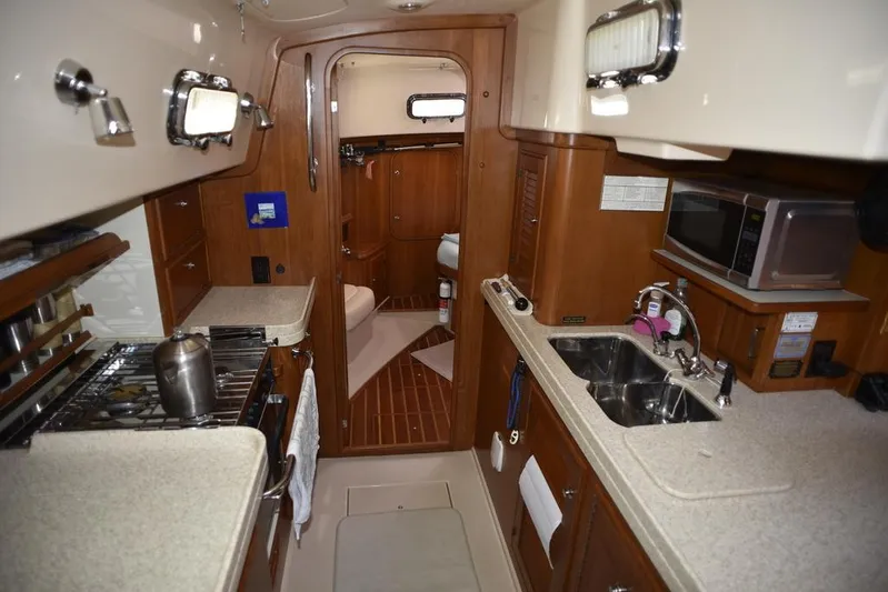 Watermark Lll Yacht Photos Pics Interior of 2005 Island Packet 445 yacht, featuring a compact kitchen with stove and sink.