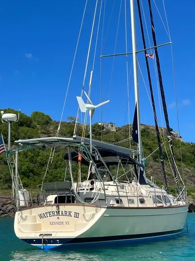 Watermark Lll Yacht Photos Pics Island Packet 445 sailboat, 2005 model, anchored in clear blue water with lush green hills.