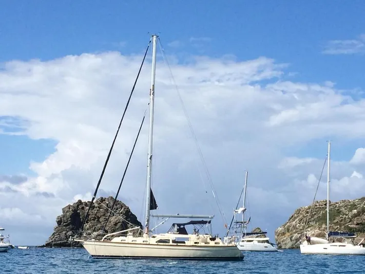 Watermark Lll Yacht Photos Pics 2005 Island Packet 445 sailboat anchored in scenic coastal waters with rocky outcrops.