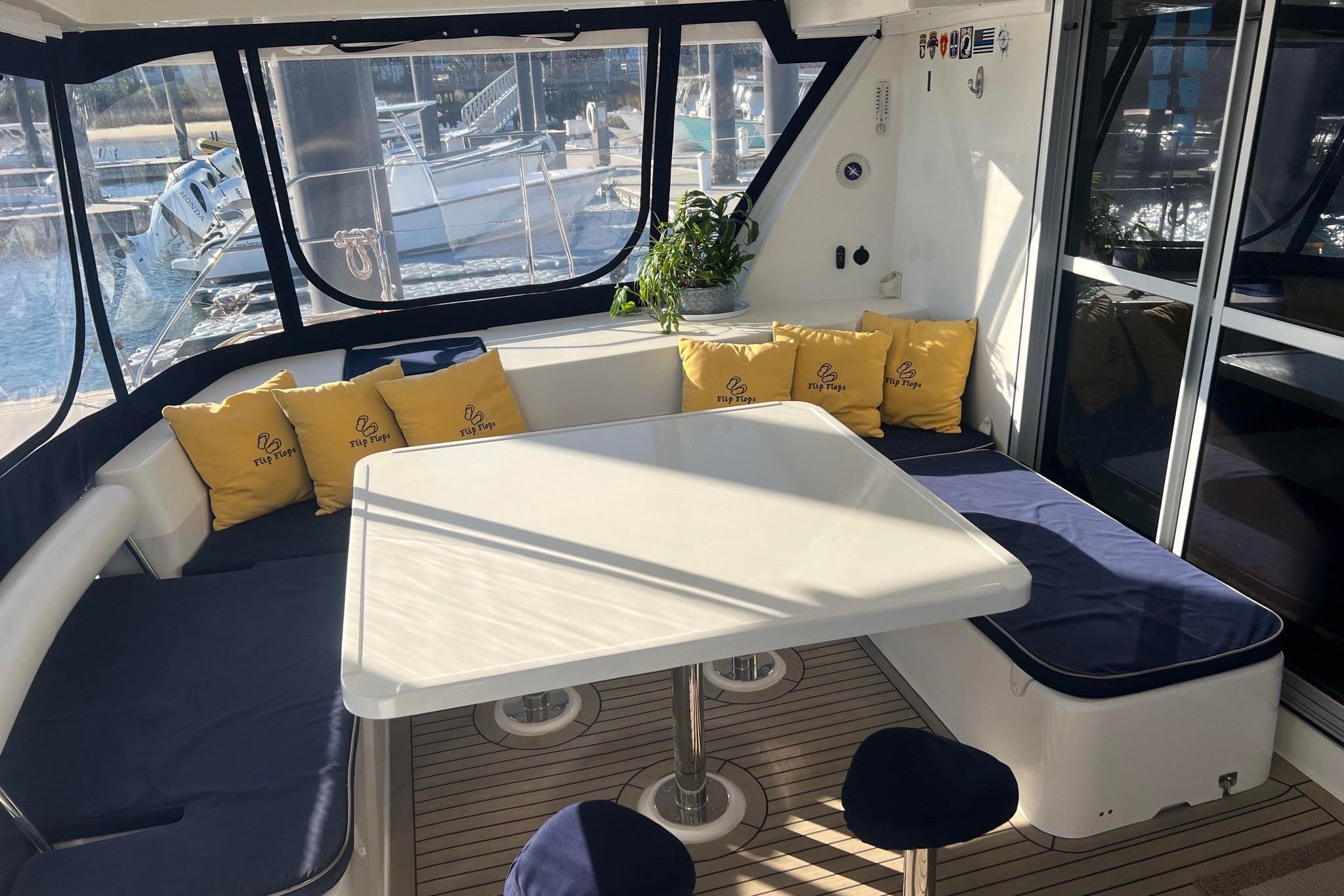 Interior of 2017 Leopard 48 yacht with cushioned seating and table, docked at marina.