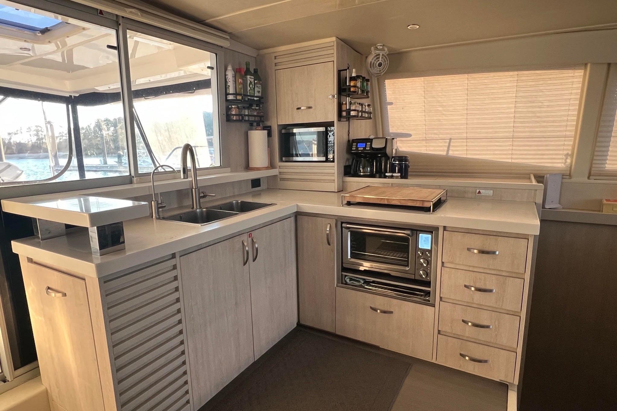Modern kitchen interior on a 2017 Leopard 48 yacht, featuring appliances and ample storage.